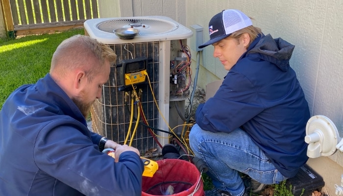 Two Technicians Looking At Condensor